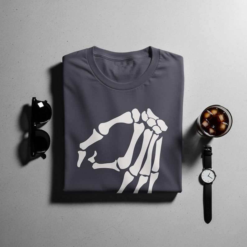 Dark gray t-shirt with white skeleton hand pointing gesture graphic.