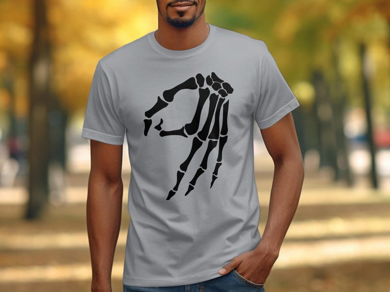Skeleton hand making the "okay" gesture on a grey t-shirt.