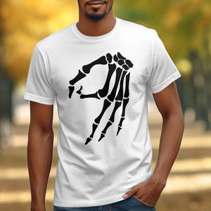 White t-shirt with black skeleton hand "okay" symbol graphic.
