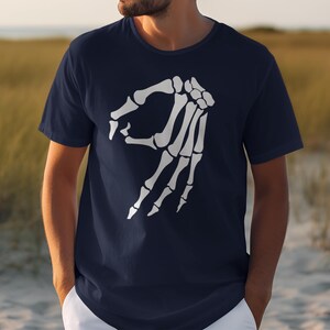 Navy t-shirt with white skeleton hand gesture graphic.