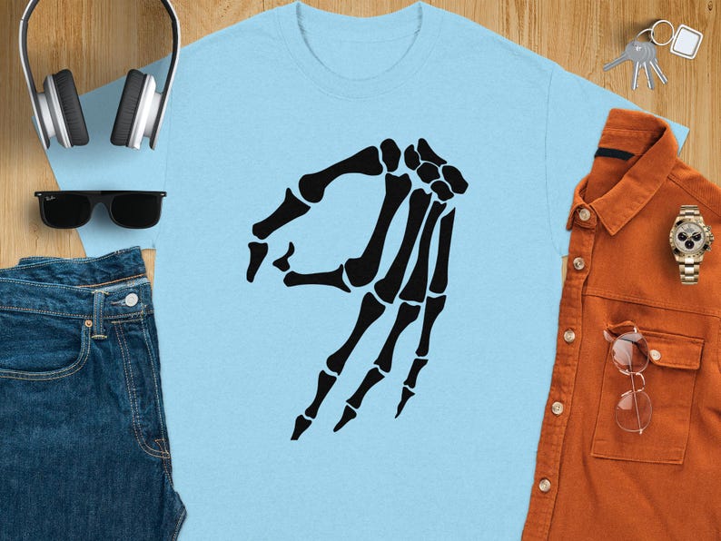 Light blue t-shirt with black skeleton hand pointing gesture.