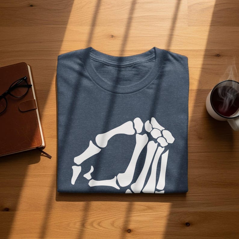 Folded navy t-shirt with a white skeleton hand graphic.