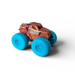 K&ouml;nnte beinhalten: Ein braunes Monstertruck-Spielzeug mit detailliertem Design, mit einem grinsenden Mund und t&uuml;rkisblauen Reifen. Das Spielzeug hat die Aufschrift "Monster Mutt" an der Seite. Das Spielzeug steht vor einem wei&szlig;en Hintergrund.