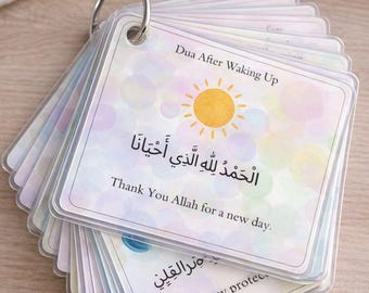 May include: A stack of prayer cards held together by a silver ring. The top card features a sun illustration and text in English and Arabic. The text reads "Dua After Waking Up" and "Thank You Allah for a new day."