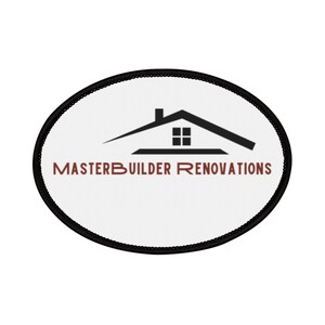 Puede incluir: Un parche ovalado con fondo blanco y borde negro. El parche presenta una silueta negra de casa con tejado y ventana. El texto "MASTERBUILDER RENOVATIONS" es de color marrón.