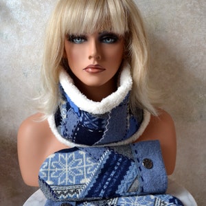 Puede incluir: Una bufanda y guantes a juego de punto azul y blanco con ribete de piel sintética blanca. La bufanda está doblada y los guantes están apilados uno encima del otro.