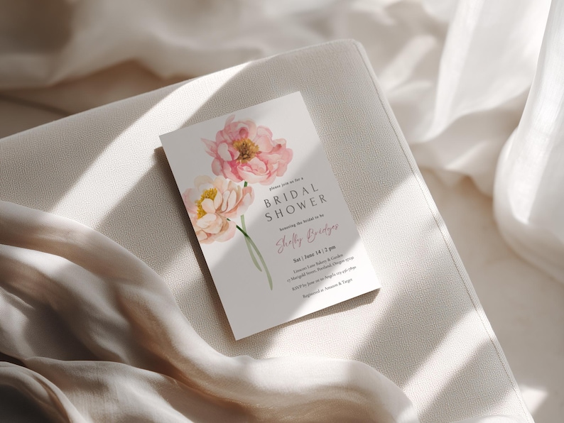 Pu&ograve; includere: Un biglietto d'invito per un addio al nubilato con fiori ad acquerello rosa e crema. Il biglietto include il testo "Bridal Shower" e il nome "Shelly Bridges". L'invito &egrave; posto su uno sfondo neutro.