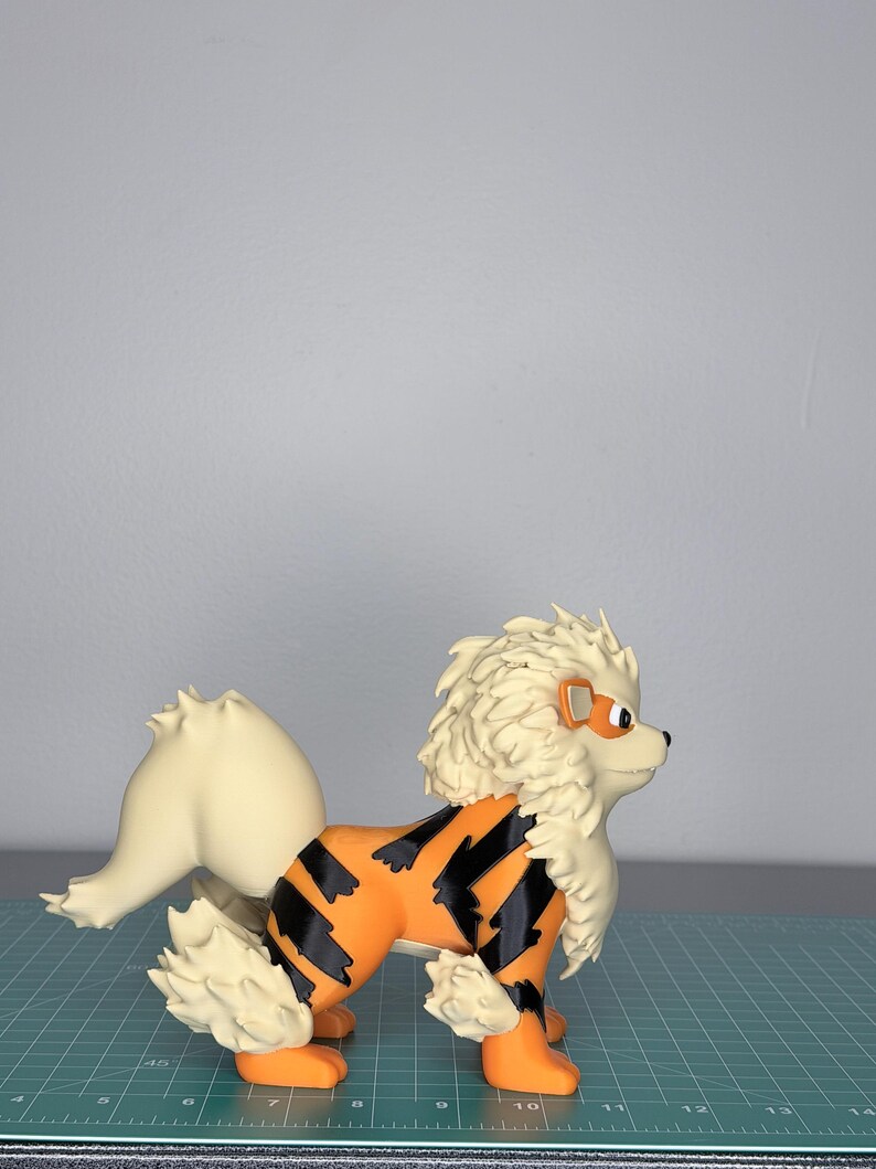 May include: A detailed figurine of a canine creature with orange and black markings, cream-colored fur, and a fluffy mane. The figurine has a determined expression and is posed in a standing position. The overall design is reminiscent of a popular animated character.