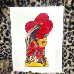 May include: A rectangular art print featuring a hammer breaking through two red heart shapes. The text reads "Let's Smash the Cis-tem". Below the hammer is a red ribbon, yellow flowers, and a small white heart with the text "Trans Liberation Now".