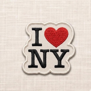 May include: Embroidered patch with the text "I ❤️ NY". The heart is red, and the letters are black. The patch has a white border and is on a cream-colored fabric background.