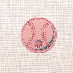 May include: A pink baseball patch with embroidered details. The patch features a baseball design with red stitching and a teal accent. A shield emblem is at the bottom of the baseball.