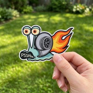 May include: A sticker featuring a cartoon snail with a turbocharger shell and flames. The snail is light blue with large orange eyes and the text "PSSHhh". The turbocharger is gray and black.