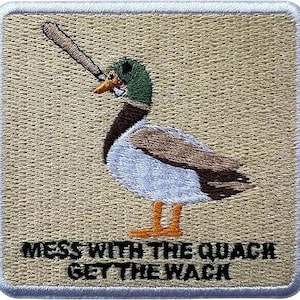 May include: Embroidered patch featuring a duck holding a baseball bat. The duck has a green head, brown and white body, and orange feet. Text at the bottom reads "MESS WITH THE QUACK GET THE WACK". The patch has a tan background and a white border.