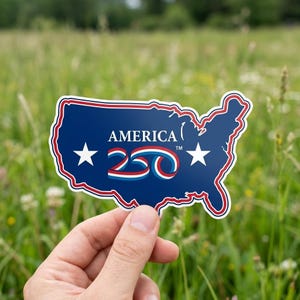 May include: A blue sticker in the shape of the United States with a red and white border. The sticker has the word "AMERICA" and the number "250" in red, white, and blue. Two white stars are on the sticker.