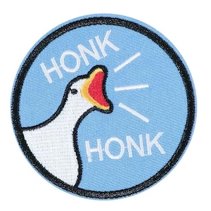 May include: A round patch with a light blue background and a black border. The patch features a white goose head with a red beak and the word "HONK" in white above and below the goose.
