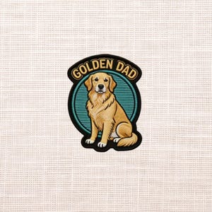May include: Embroidered patch featuring a golden retriever dog with the text "GOLDEN DAD" in a black and gold banner. The dog is sitting inside a teal circle with a black border. The patch has a white background.