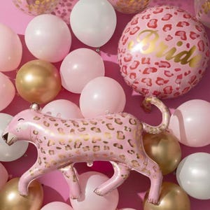 Peut inclure: Un ensemble de ballons comprenant des sphères unies rose clair, blanches et or métallisé, des ballons transparents remplis de confettis dorés, un grand ballon rond à motif léopard rose avec le mot Bride, et un ballon en aluminium léopard rose.