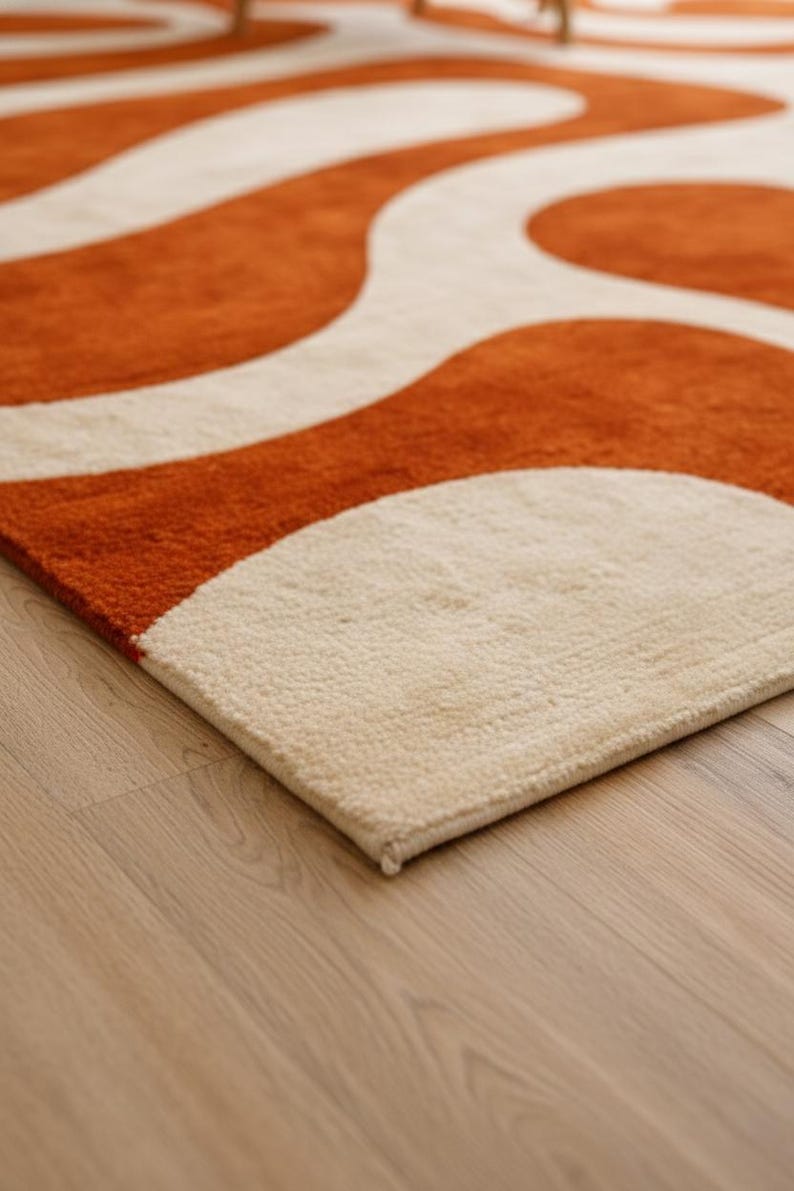 A corner angle of the Large Burnt Orange Rug for Living Room laying flat on a light wood floor. This shot displays the durable backing and the vibrant Retro 70s design, perfect for Mid Century Modern Decor styling.