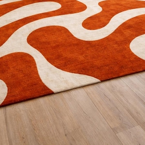 Close-up of the thick, soft texture of the Hand Tufted Wool Rug showing the premium quality material and detailed Wavy Abstract stitching in Burnt Orange.