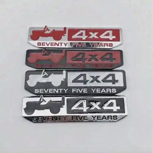 May include: Four metal Jeep emblems in red, black, and silver. Each emblem features a Jeep silhouette, the text "4x4", and "SEVENTY FIVE YEARS". The emblems are rectangular and have a glossy finish.