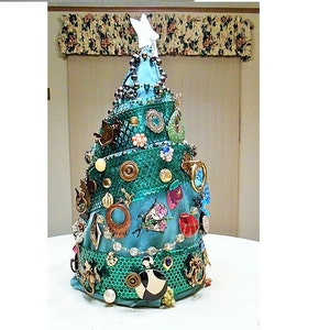 May include: A turquoise blue Christmas tree decorated with various vintage brooches, buttons, and other trinkets. The tree is topped with a white butterfly.