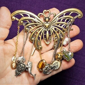REA Stor genomborrad mässingsfjäril CHATELAINE 10 slipsnålar, 2 snäckskalskameos, fisk, scrimshaw, ankare, propellrar, lejon, delfin, ädelstenar,