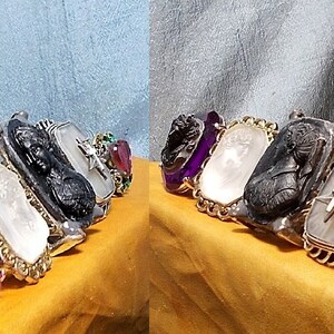 May include: A set of seven rings featuring a variety of intaglio designs. The rings are crafted from black onyx, white agate, and gold, and are adorned with amethyst, ruby, and emerald gemstones.