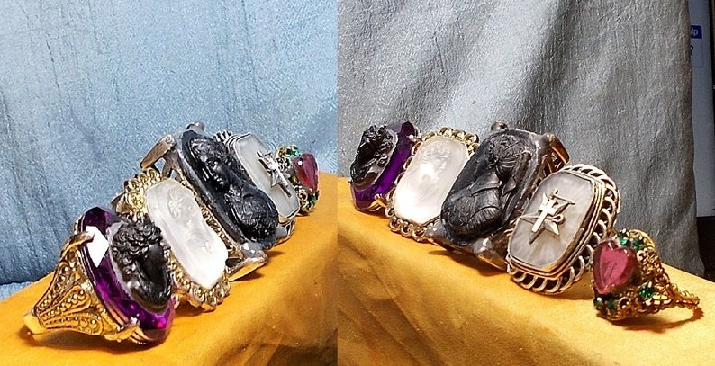 May include: A set of seven rings featuring a variety of intaglio designs. The rings are crafted from black onyx, white agate, and gold, and are adorned with amethyst, ruby, and emerald gemstones.