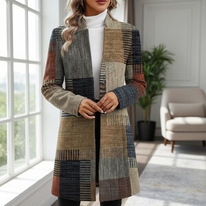 May include: A patchwork coat in shades of brown, grey, and blue. The coat features a long, open design with a collar and a belt. The fabric has a textured appearance, and the sleeves have a colour gradient. The coat is knee-length.