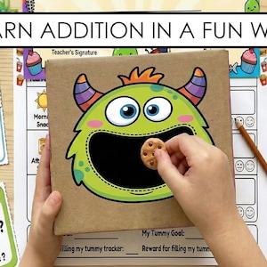 Puede incluir: Juego educativo con el texto "APRENDER A SUMAR DE FORMA DIVERTIDA". El juego presenta una caja con temática de monstruos con una galleta en la boca y problemas de suma en tarjetas con ilustraciones coloridas.
