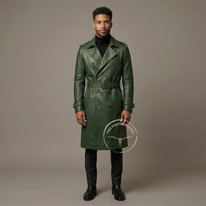 May include: A long, green leather trench coat with a double-breasted design and a belt at the waist. The coat has a classic trench coat style with a notched collar and button details. The coat is worn with black pants and a black turtleneck.