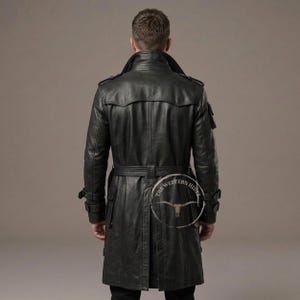 May include: Black leather trench coat with a belted waist, notched lapels, and multiple pockets. The coat has a classic design with a long length, suitable for various occasions. The back view showcases the coat's tailored fit and details.
