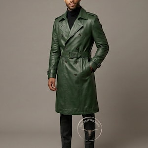 May include: A long, forest green leather trench coat with a double-breasted design, a belt at the waist, and a classic collar. The coat has a knee-length hem and is worn with black pants.