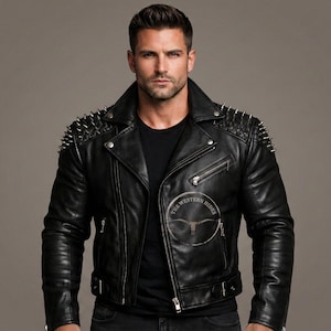 May include: Black leather jacket with silver spike detailing on the shoulders. The jacket has a notched collar, an asymmetrical zip, and a logo patch that reads "THE WESTERN HIDES". The jacket is worn over a black t-shirt.