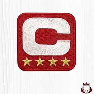 May include: Embroidered red patch with a white "C" design and four gold stars at the bottom. The patch has a square shape with rounded corners. The design is stitched with white thread.