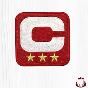 May include: Red embroidered patch with a white letter "C" and three gold stars. The patch has a square shape with rounded corners. The design is likely for a sports team or organization.
