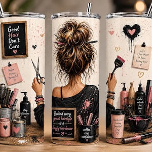 May include: Three cylindrical tumblers with metal straws featuring a hairdresser theme. The design includes illustrations of a person with a messy bun, hair styling tools, hearts, and text such as Good Hair Don't Care and Behind every great hairstyle is a happy hairdresser.
