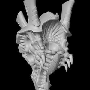 Puede incluir: Modelo detallado en gris claro impreso en 3D de la cabeza de una criatura, con dientes afilados, armadura segmentada y múltiples protuberancias en forma de cuerno. El diseño tiene una estética biomecánica, con detalles intrincados y una apariencia amenazante.