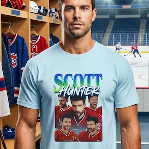 Puede incluir: Camiseta azul claro con el nombre "SCOTT HUNTER" en verde y azul, y un collage de fotos de un hombre con una camiseta de hockey roja. El fondo muestra equipo de hockey y una pista de hielo.