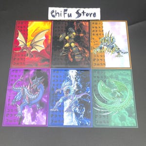 May include: A collection of six trading card game cards featuring fantasy creatures. Each card has a unique design with vibrant colors, including dragons, warriors, and other mythical beings. The cards have a border and some have text in a foreign language. The text "Chifu Store" is at the top.
