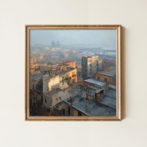 May include: A square framed oil painting depicting a cityscape at dusk. The scene features multi-story buildings with flat roofs in shades of beige, gray, and orange, illuminated by warm light. A harbor with ships is visible in the hazy distance.