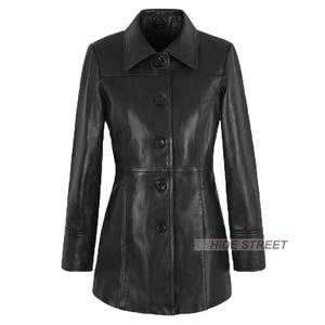 Könnte beinhalten: Schwarze Lederjacke mit Knopfleiste, Kragen und langen Ärmeln. Die Jacke hat eine taillierte Passform und ein klassisches Design. Die Jacke ist etwa 91 cm lang.