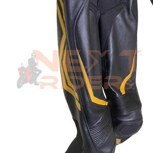 Op de afbeelding: Zwarte leren motorbroek met gele accenten. De broek heeft een gestroomlijnd ontwerp met versterkte panelen en een getextureerde afwerking. De gele details zorgen voor een opvallend contrast met het zwarte leer.