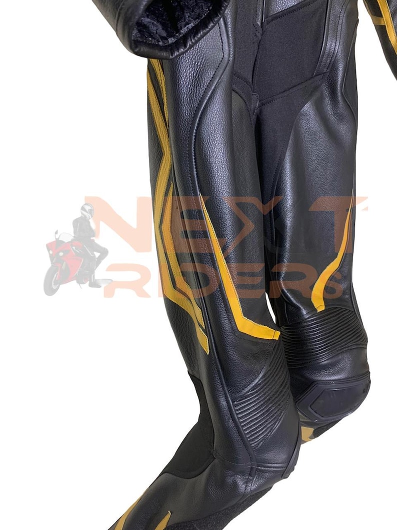 Op de afbeelding: Zwarte leren motorbroek met gele accenten. De broek heeft een gestroomlijnd ontwerp met versterkte panelen en een getextureerde afwerking. De gele details zorgen voor een opvallend contrast met het zwarte leer.