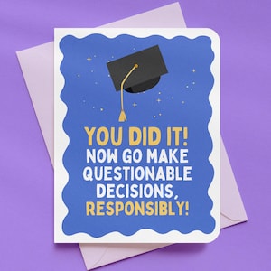 May include: A graduation greeting card with a blue background and a black graduation cap illustration. The card reads, "YOU DID IT! NOW GO MAKE QUESTIONABLE DECISIONS, RESPONSIBLY!" The card is inside a light purple envelope.