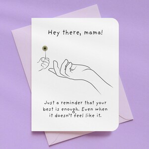 May include: A greeting card with the text "Hey there, mama!" and a line drawing of a hand holding a dandelion. The card also includes the text "Just a reminder that your best is enough. Even when it doesn't feel like it."