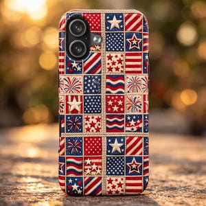 May include: A phone case with a patriotic design featuring red, white, and blue squares. The squares display stars, stripes, and fireworks. The case has a stitched border and a camera cutout.