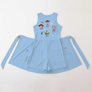 May include: A light blue sleeveless romper featuring two front pockets and a graphic print of Toy Story characters including Woody, Jessie, Bo Peep, and Buzz Lightyear, with their names printed below each character and small star and cloud icons.