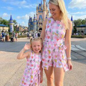 Może przedstawiać: Biały ceramiczny kubek z czarnym uchwytem i napisem "But First, Coffee" czarną, odręczną czcionką. Kubek stoi na białej powierzchni.