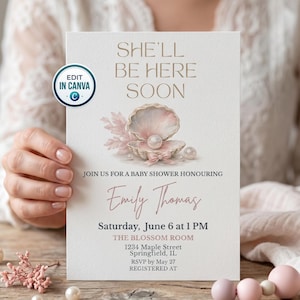 May include: Baby shower invitation with the text "She'll Be Here Soon." The design features a seashell with a pearl, and the invitation includes details for Emily Thomas's baby shower on June 6 at 1 PM in Springfield, IL.